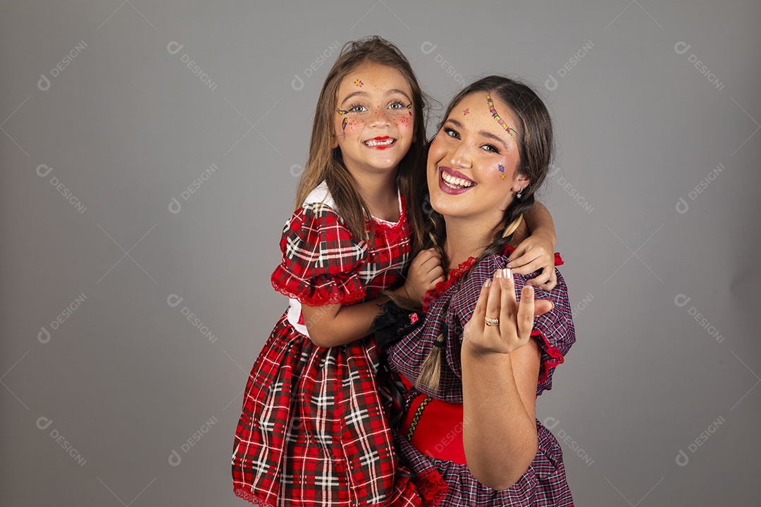 Mãe ao lado de sua filha usando roupas típicas festa junina sobre fundo isolado