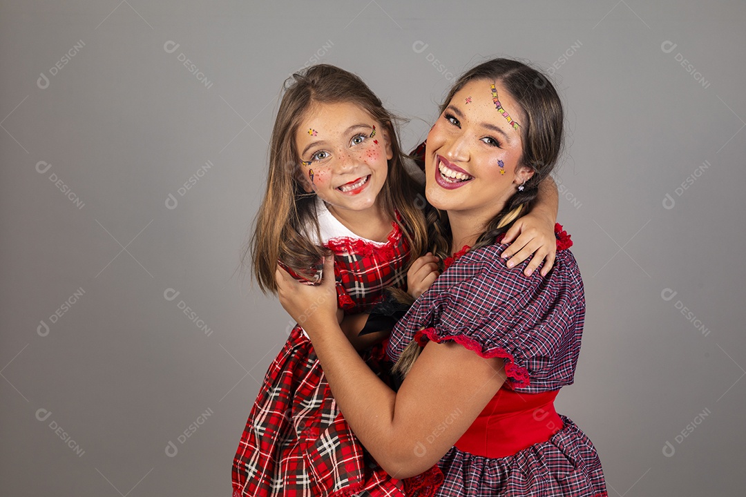 Mãe ao lado de sua filha usando roupas típicas festa junina sobre fundo isolado
