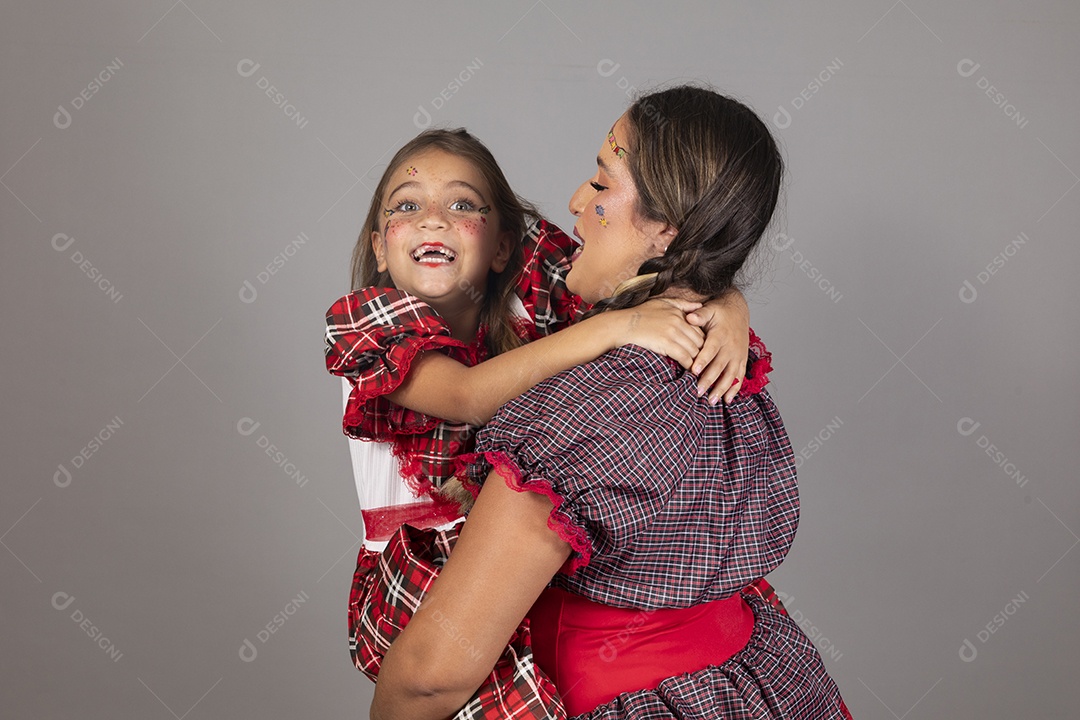 Mãe ao lado de sua filha usando roupas típicas festa junina sobre fundo isolado