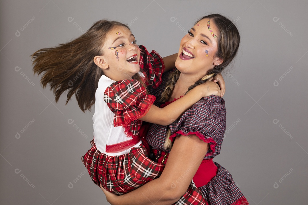 Mãe ao lado de sua filha usando roupas típicas festa junina sobre fundo isolado