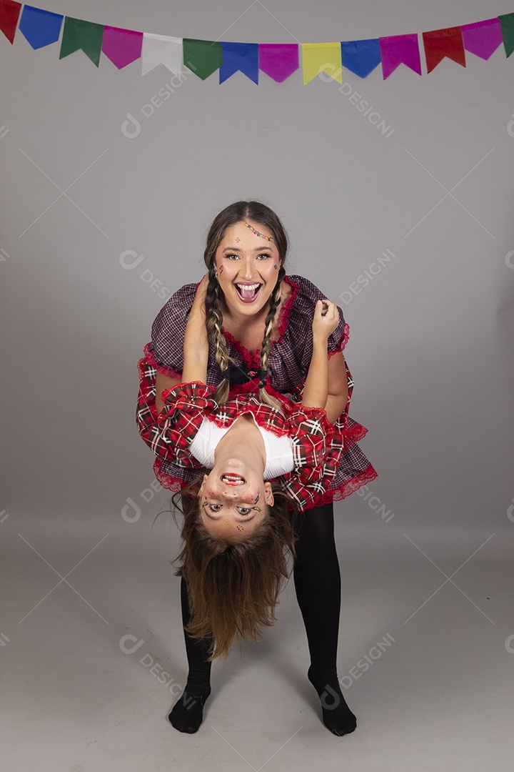 Mãe ao lado de sua filha usando roupas típicas festa junina sobre fundo isolado