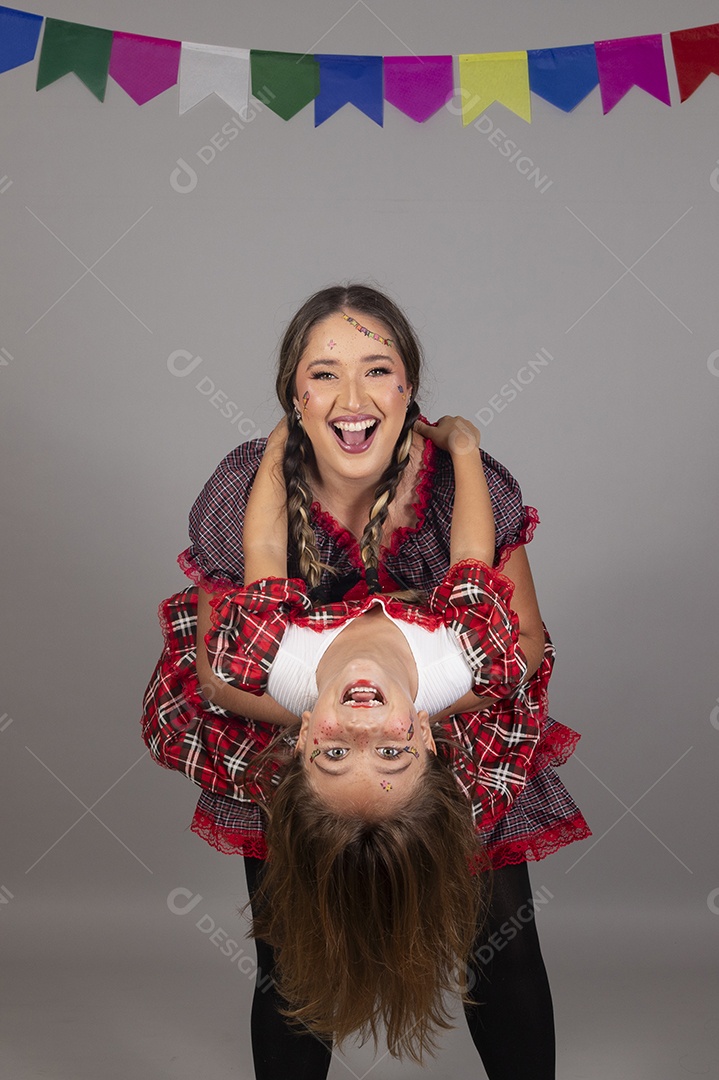 Mãe ao lado de sua filha usando roupas típicas festa junina sobre fundo isolado