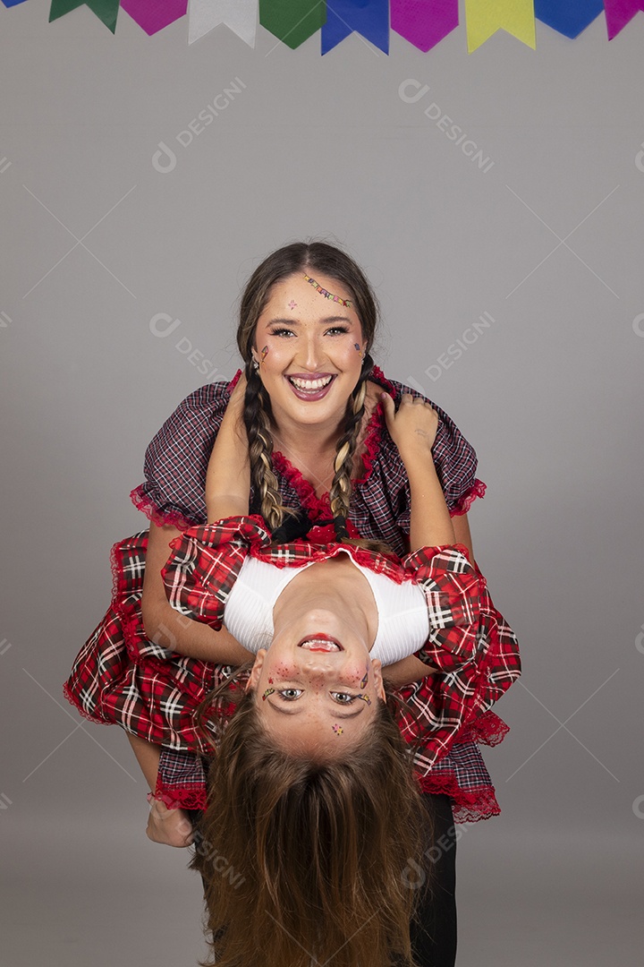 Mãe ao lado de sua filha usando roupas típicas festa junina sobre fundo isolado