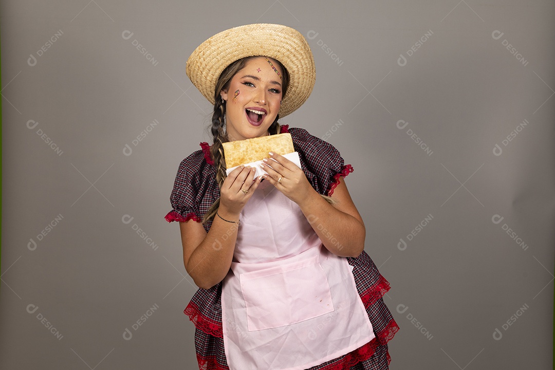 Mulher linda jovem usando roupas típicas festa junina sobre fundo isolado se alimentando