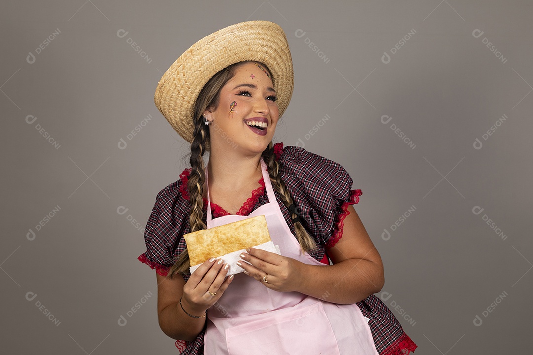 Mulher linda jovem usando roupas típicas festa junina sobre fundo isolado se alimentando