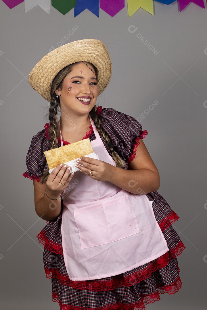 Mulher linda jovem usando roupas típicas festa junina sobre fundo isolado se alimentando