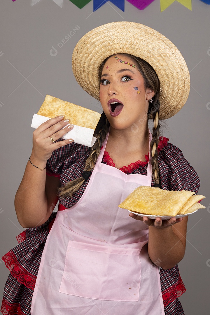 Mulher linda jovem usando roupas típicas festa junina sobre fundo isolado se alimentando