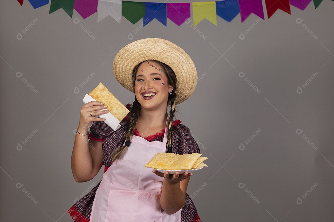 Mulher linda jovem usando roupas típicas festa junina sobre fundo isolado se alimentando