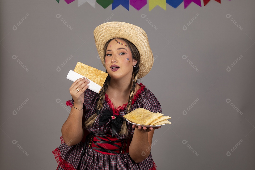 Mulher linda jovem usando roupas típicas festa junina sobre fundo isolado se alimentando