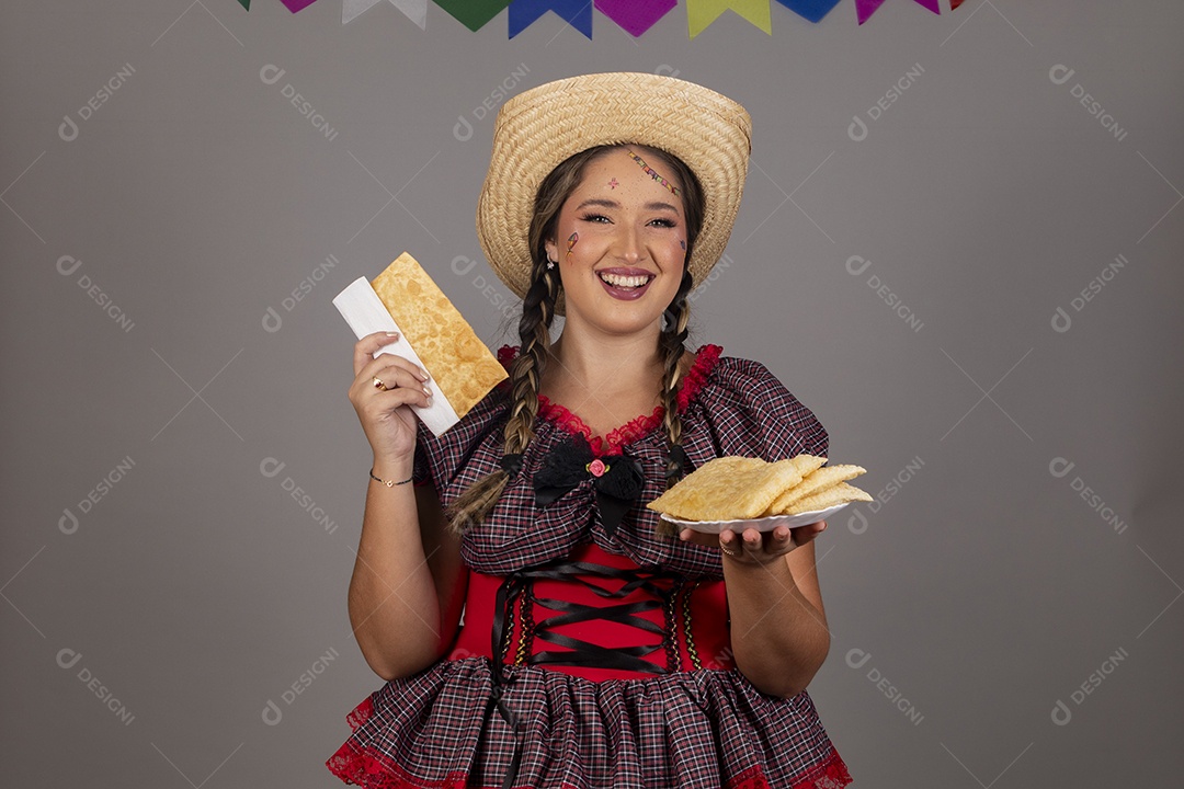 Mulher linda jovem usando roupas típicas festa junina sobre fundo isolado se alimentando