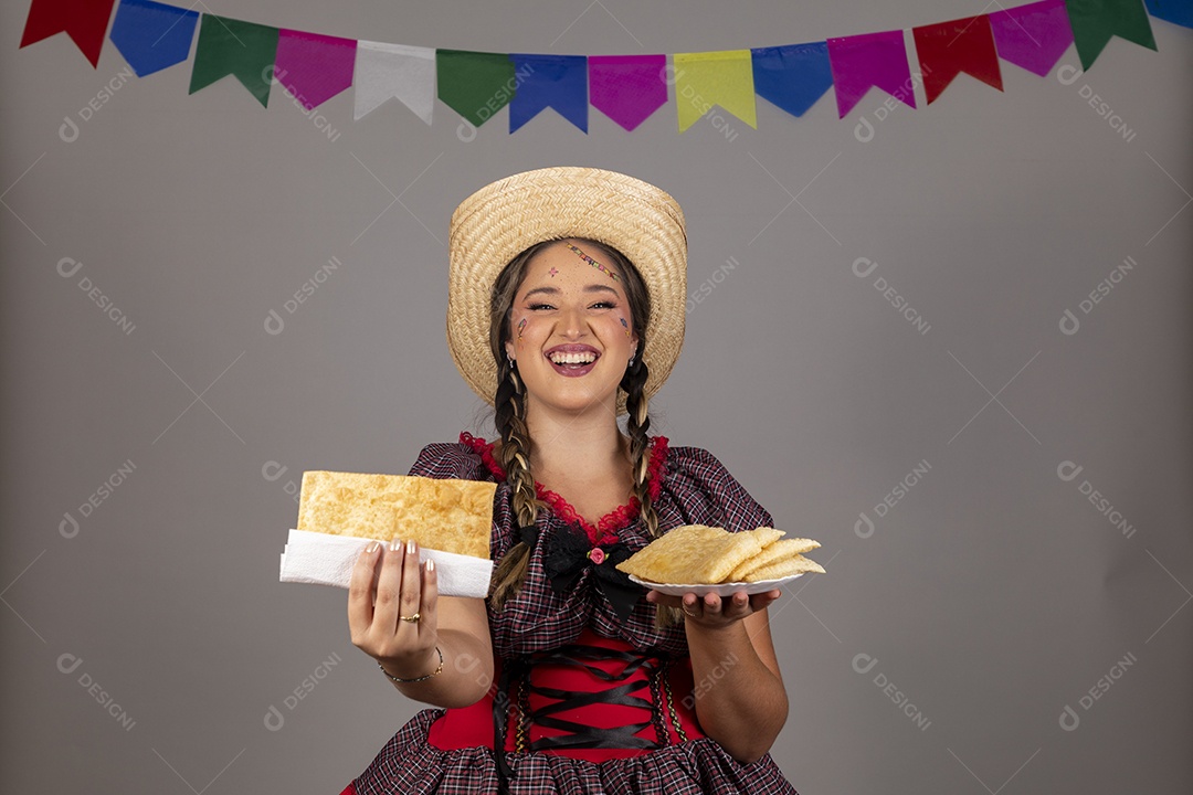 Mulher linda jovem usando roupas típicas festa junina sobre fundo isolado se alimentando