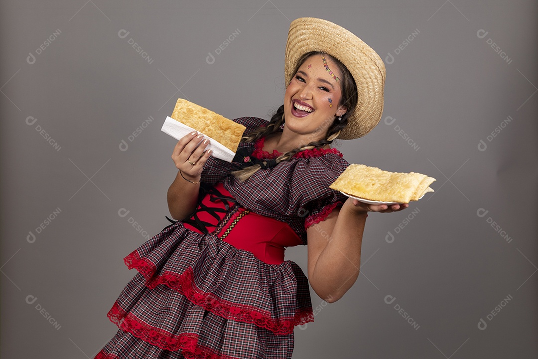 Mulher linda jovem usando roupas típicas festa junina sobre fundo isolado se alimentando