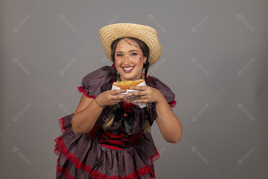Mulher linda jovem usando roupas típicas festa junina sobre fundo isolado se alimentando