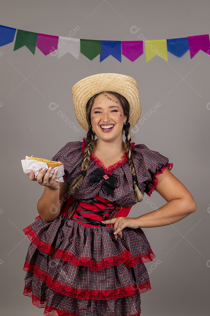 Mulher linda jovem usando roupas típicas festa junina sobre fundo isolado se alimentando