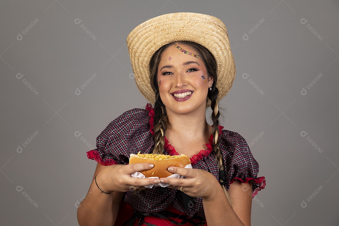 Mulher linda jovem usando roupas típicas festa junina sobre fundo isolado segurando bolo