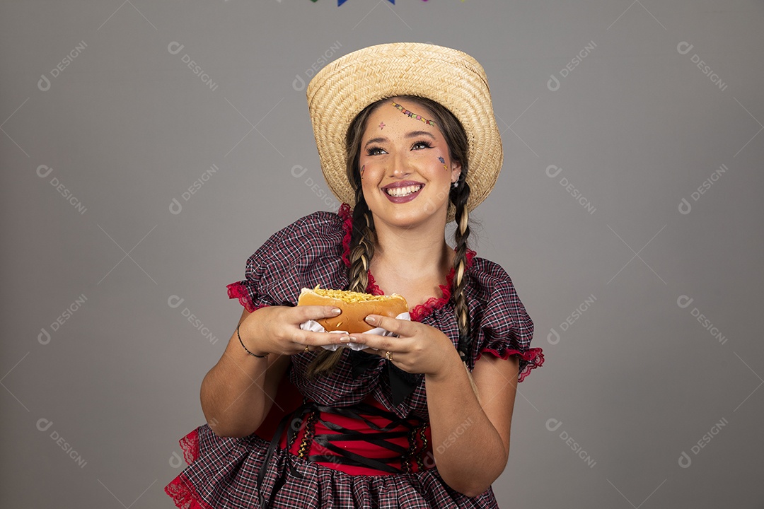 Mulher linda jovem usando roupas típicas festa junina sobre fundo isolado segurando bolo