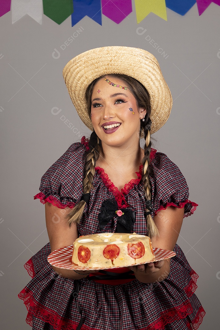 Mulher linda jovem usando roupas típicas festa junina sobre fundo isolado segurando bolo