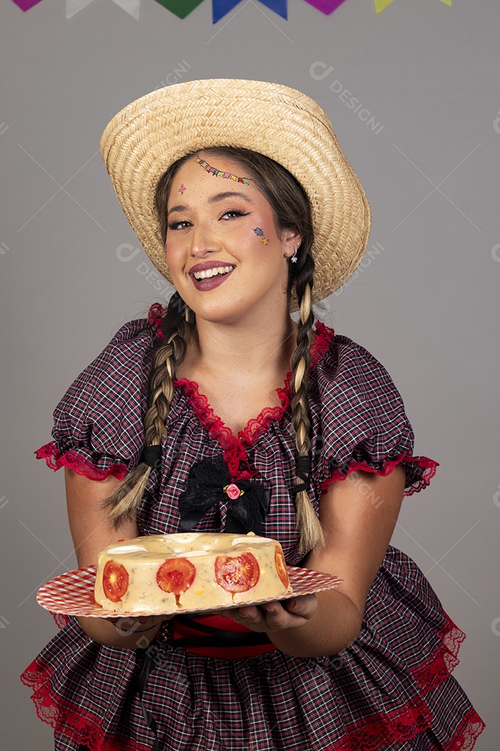 Mulher linda jovem usando roupas típicas festa junina sobre fundo isolado segurando bolo