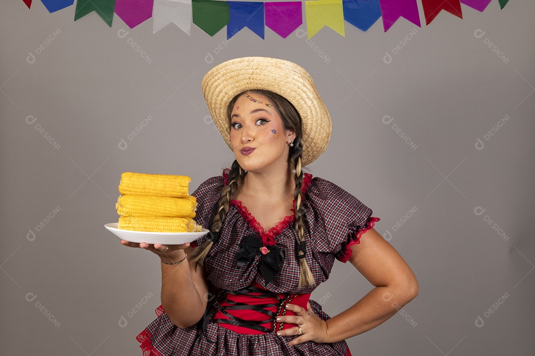 Mulher linda jovem usando roupas típicas festa junina sobre fundo isolado se alimentando