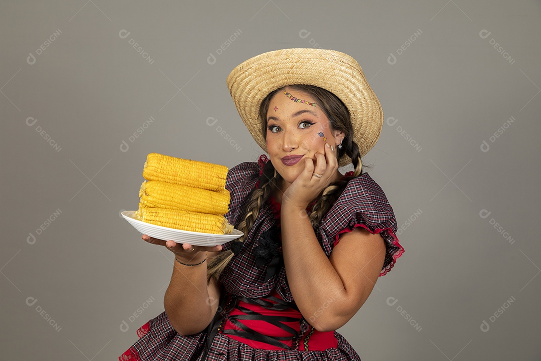 Mulher linda jovem usando roupas típicas festa junina sobre fundo isolado se alimentando