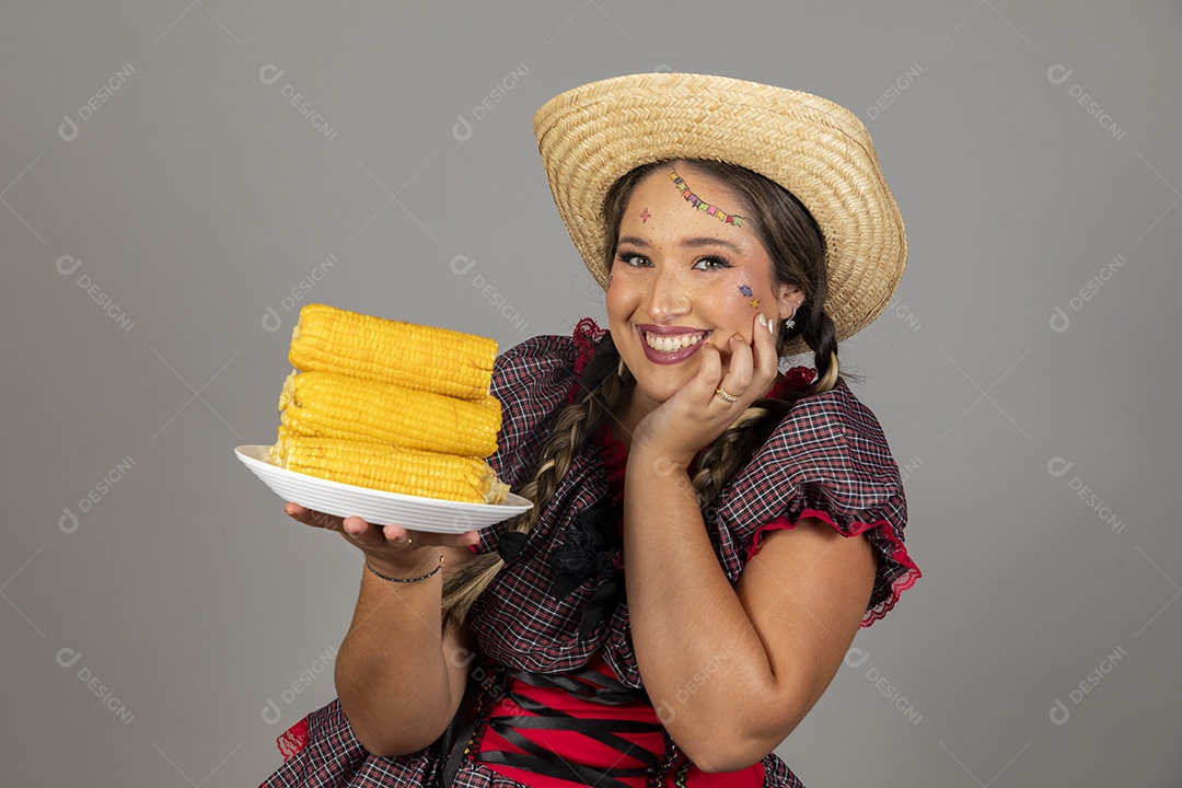 Mulher linda jovem usando roupas típicas festa junina sobre fundo isolado se alimentando