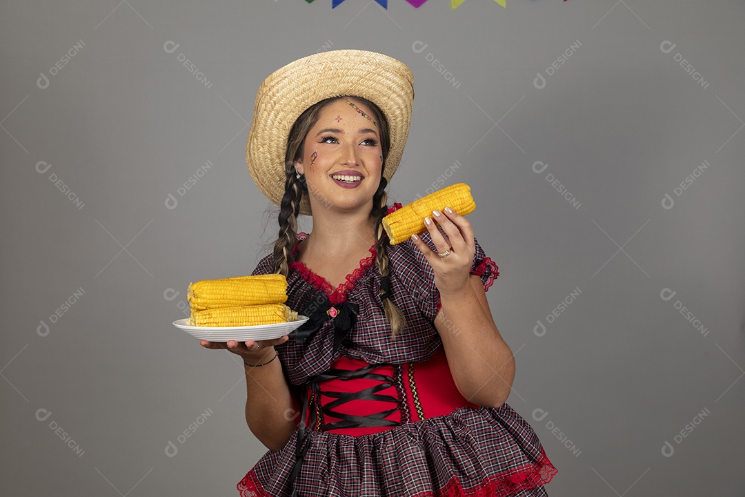 Mulher linda jovem usando roupas típicas festa junina sobre fundo isolado se alimentando