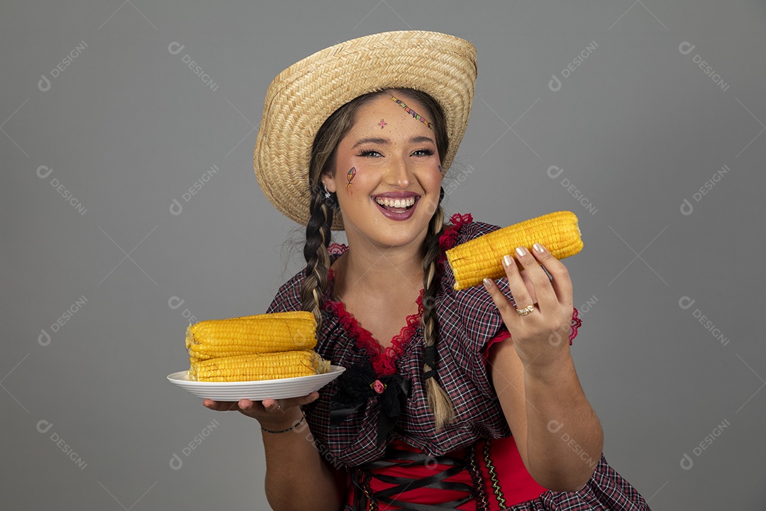 Mulher linda jovem usando roupas típicas festa junina sobre fundo isolado se alimentando