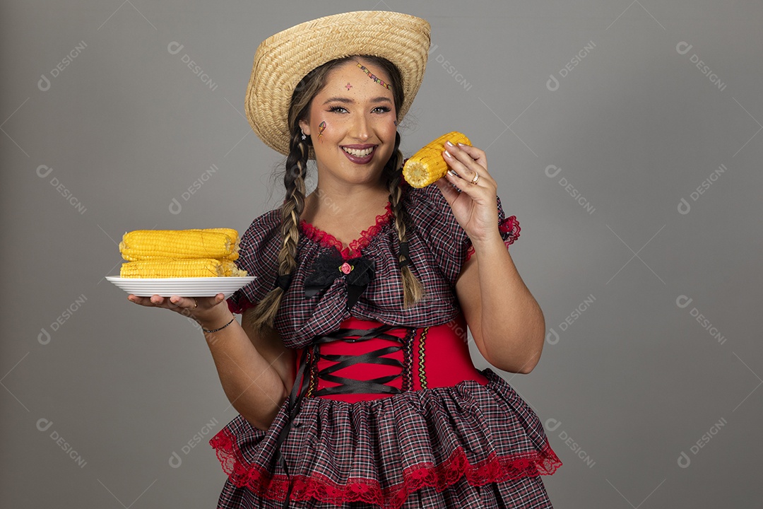 Mulher linda jovem usando roupas típicas festa junina sobre fundo isolado se alimentando
