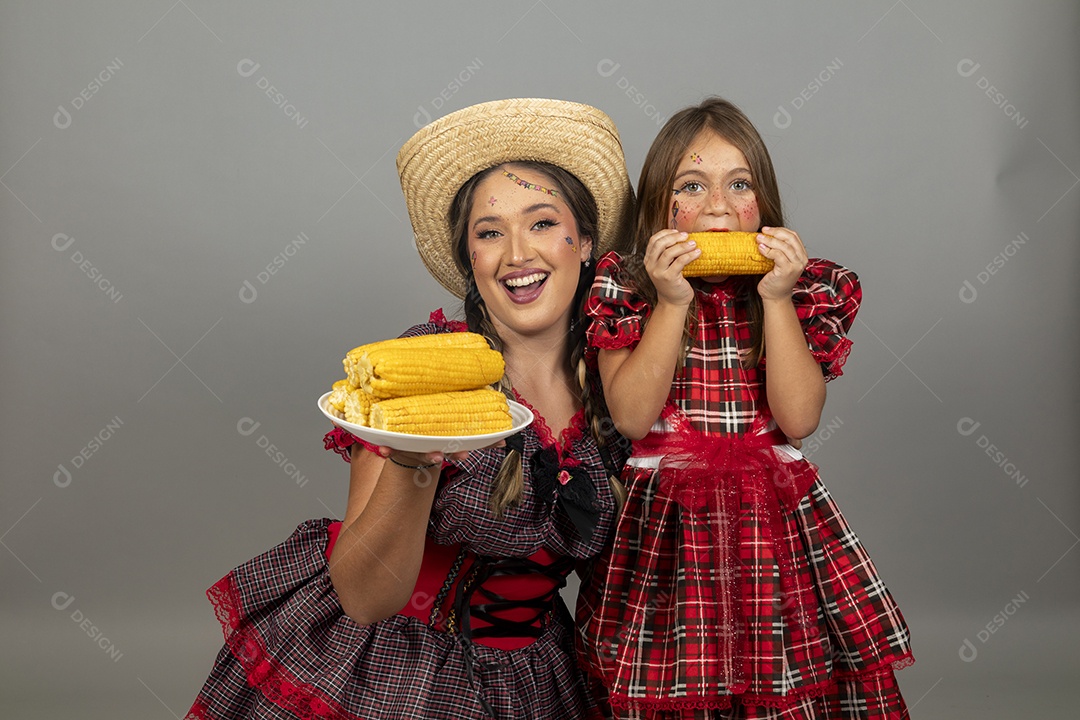Mãe jovem usando roupas típicas festa junina sobre fundo isolado ao lado de sua filha