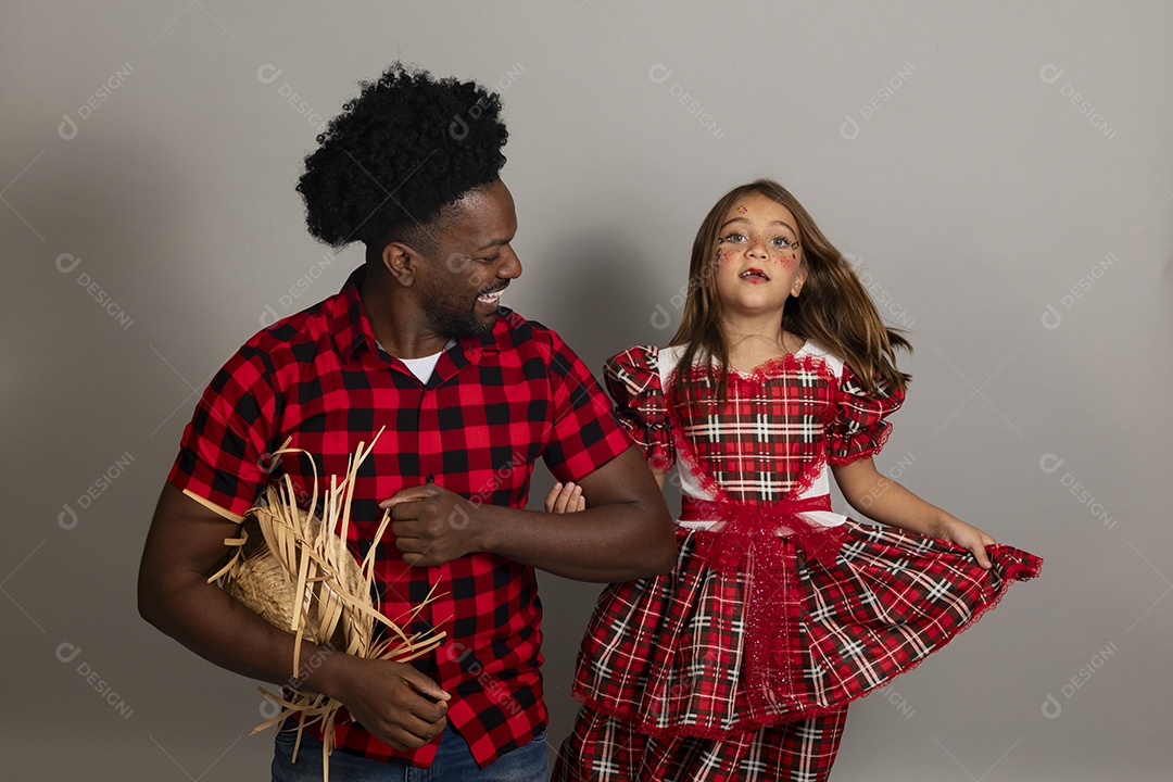Pai jovem usando roupas típicas festa junina sobre fundo isolado ao lado de sua filha