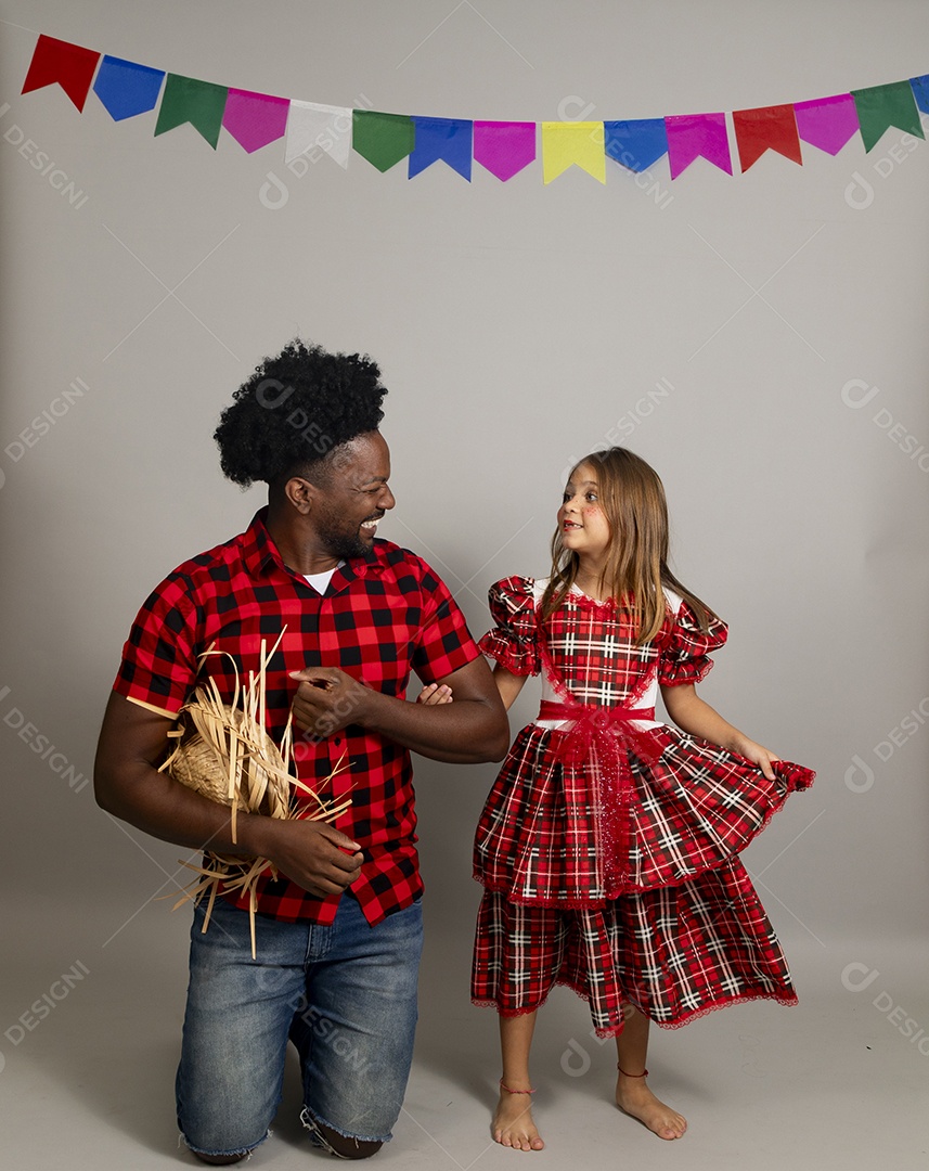 Pai jovem usando roupas típicas festa junina sobre fundo isolado ao lado de sua filha