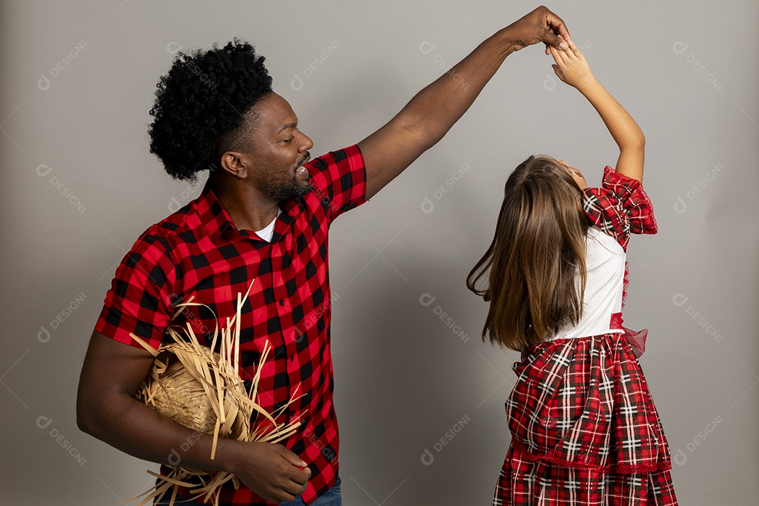 Pai jovem usando roupas típicas festa junina sobre fundo isolado ao lado de sua filha