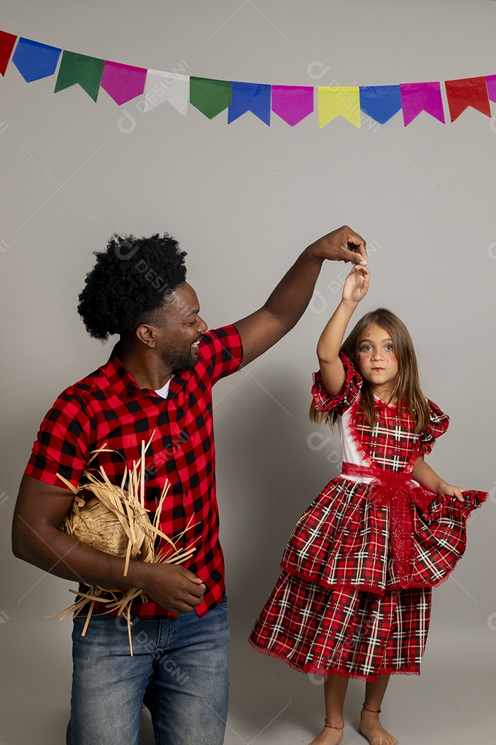 Pai jovem usando roupas típicas festa junina sobre fundo isolado ao lado de sua filha