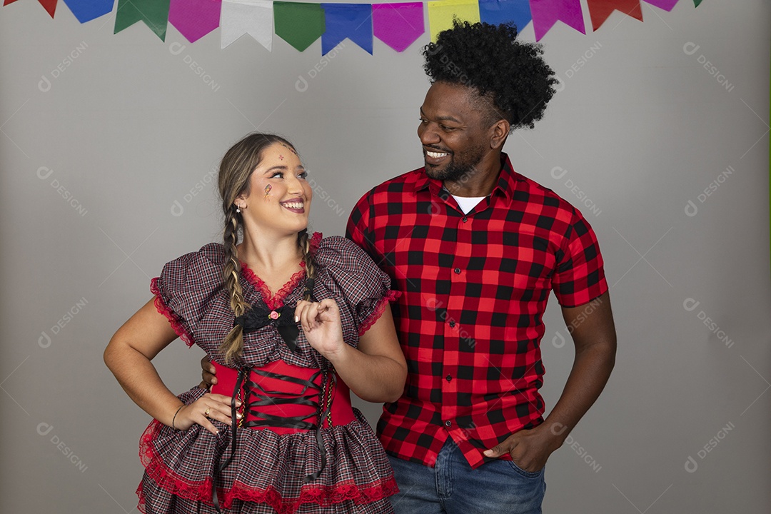 Lindo casal de jovens ao lado de sua filha celebrando festa junina usando roupas típicas