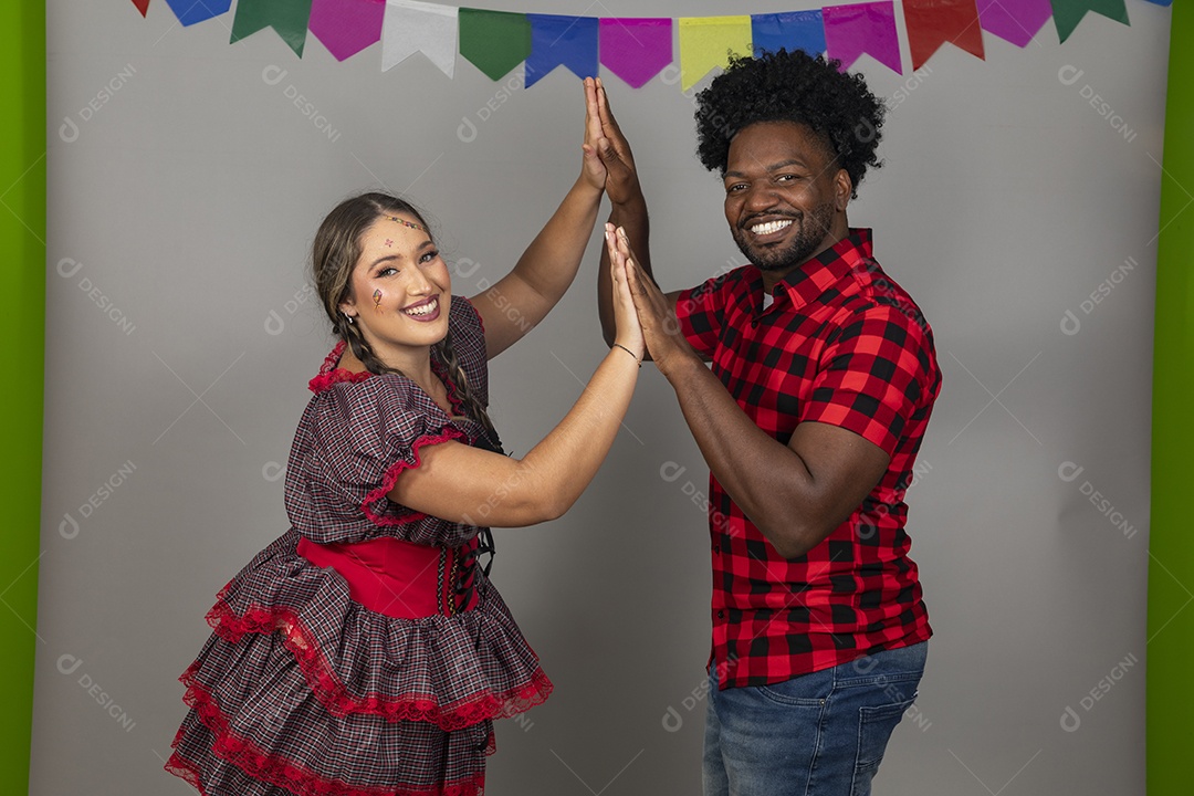 Lindo casal de jovens ao lado de sua filha celebrando festa junina usando roupas típicas