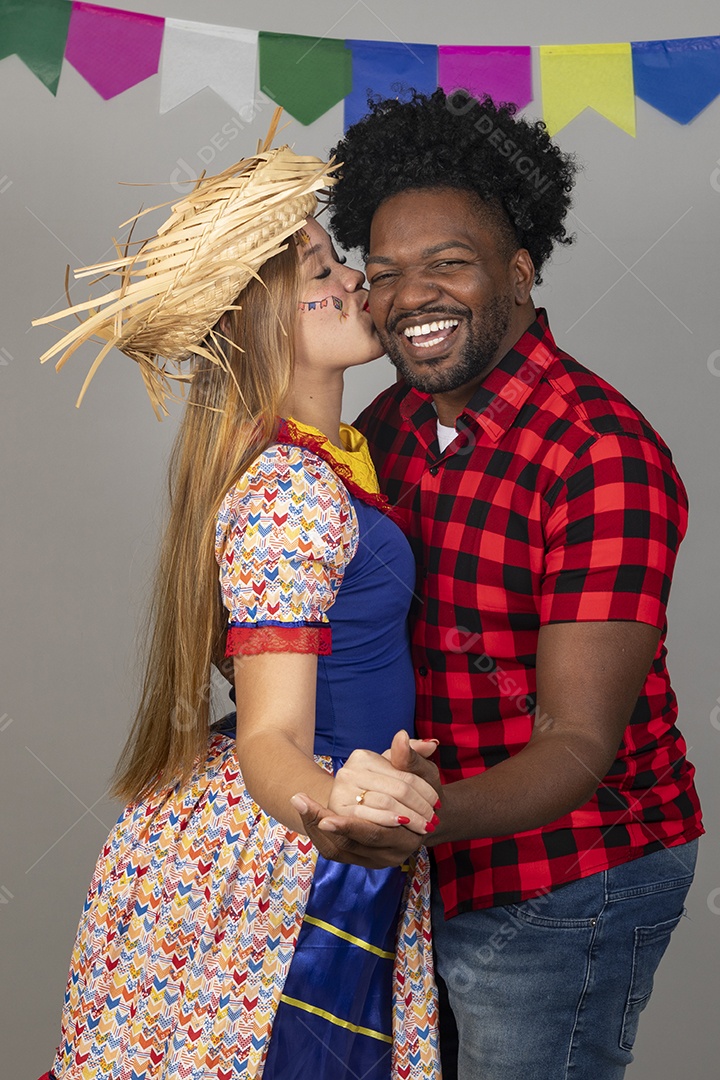 Lindo casal de jovens celebrando festa junina usando roupas típicas