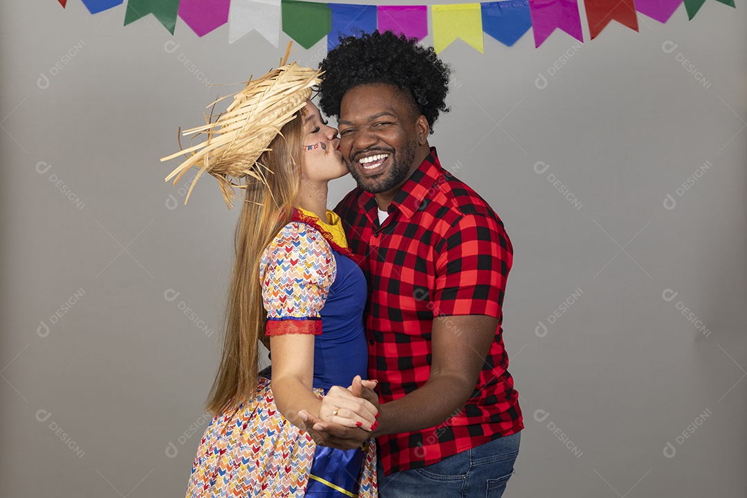 Lindo casal de jovens celebrando festa junina usando roupas típicas