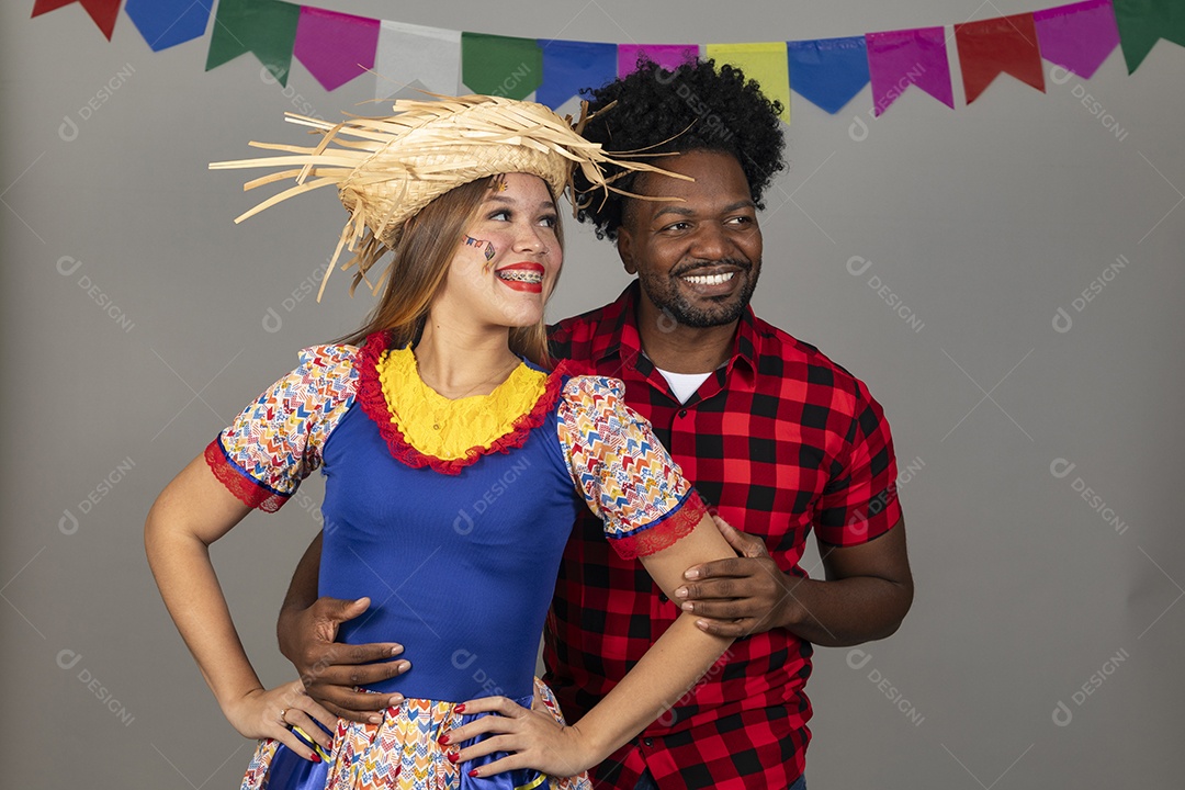 Lindo casal de jovens ao lado de sua filha celebrando festa junina usando roupas típicas