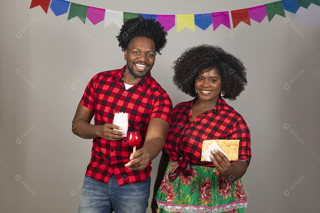 Lindo casal de jovens ao lado de sua filha celebrando festa junina usando roupas típicas