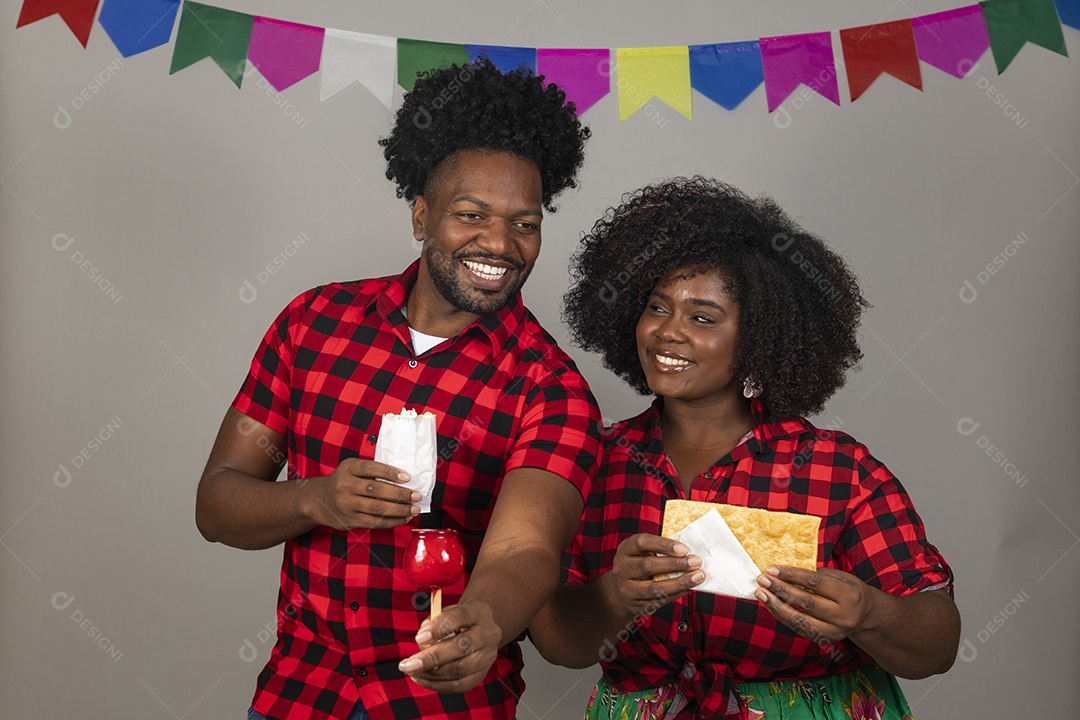 Lindo casal de jovens ao lado de sua filha celebrando festa junina usando roupas típicas