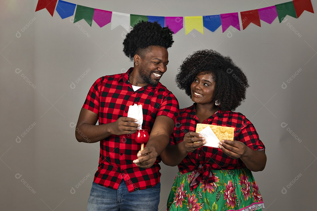 Lindo casal de jovens ao lado de sua filha celebrando festa junina usando roupas típicas