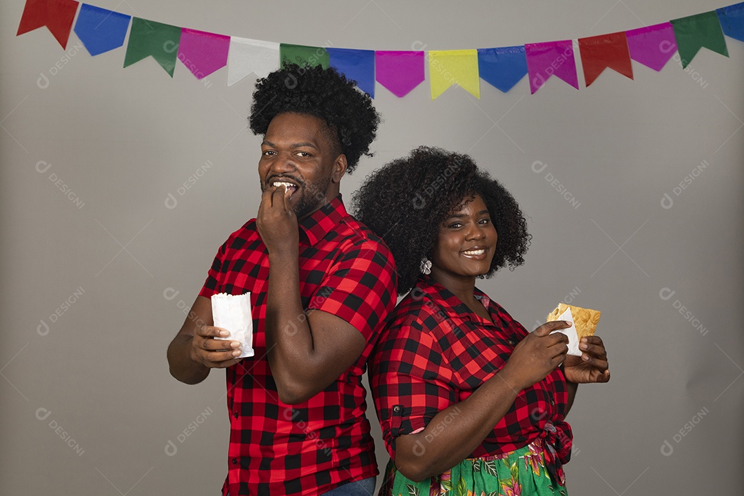 Lindo casal de jovens ao lado de sua filha celebrando festa junina usando roupas típicas