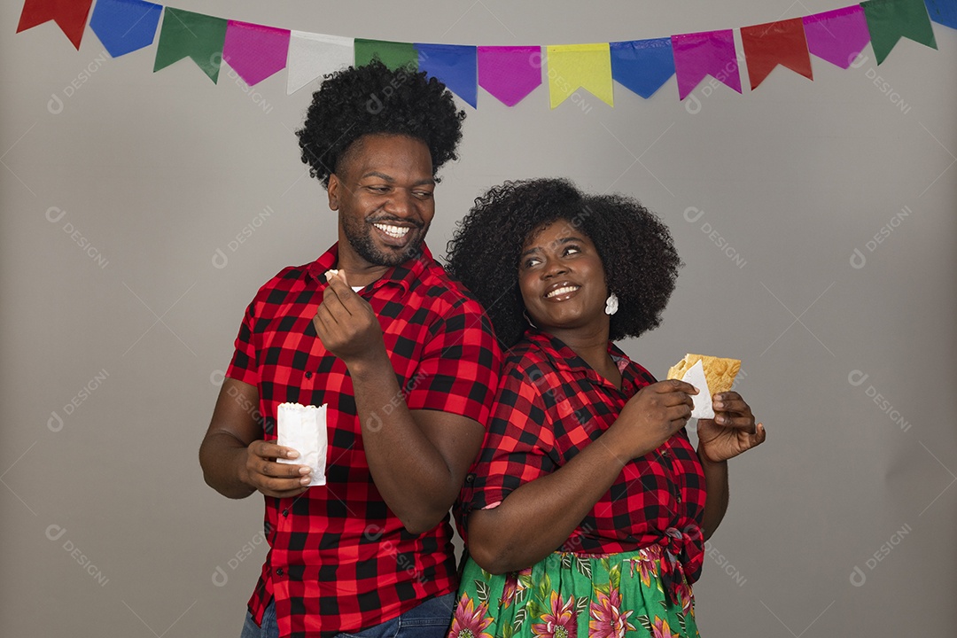Lindo casal de jovens ao lado de sua filha celebrando festa junina usando roupas típicas