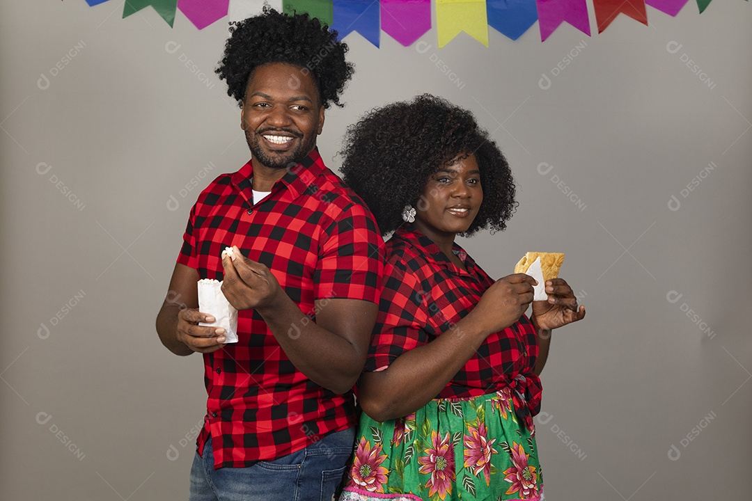 Lindo casal de jovens ao lado de sua filha celebrando festa junina usando roupas típicas