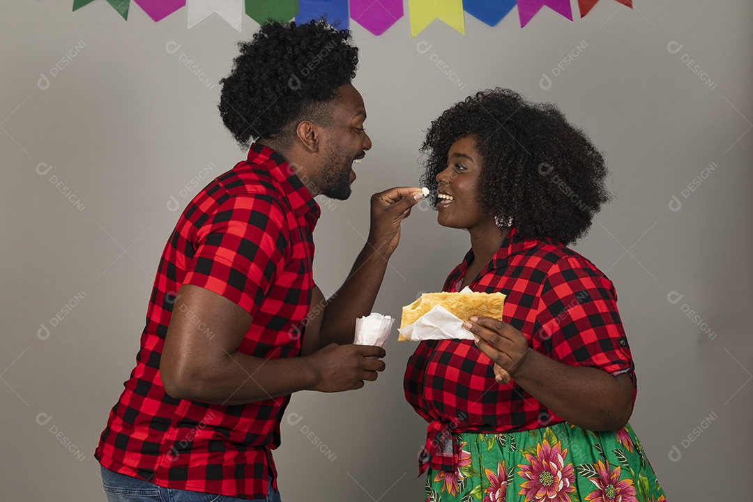 Lindo casal de jovens ao lado de sua filha celebrando festa junina usando roupas típicas