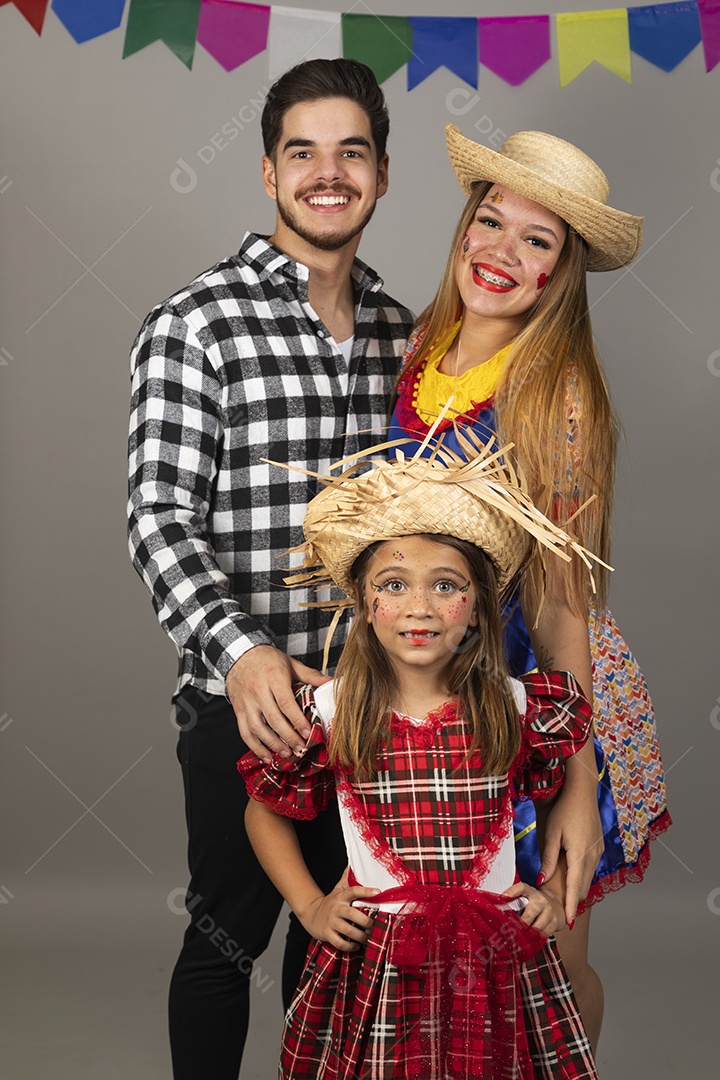 Lindo casal de jovens ao lado de sua filha celebrando festa junina usando roupas típicas