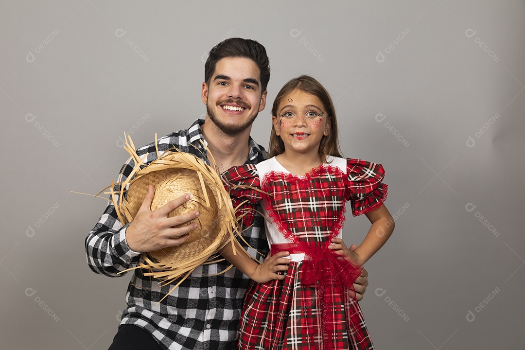 Pai jovem usando roupas típicas festa junina ao lado de sua filha