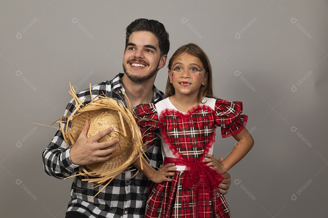 Pai jovem usando roupas típicas festa junina ao lado de sua filha