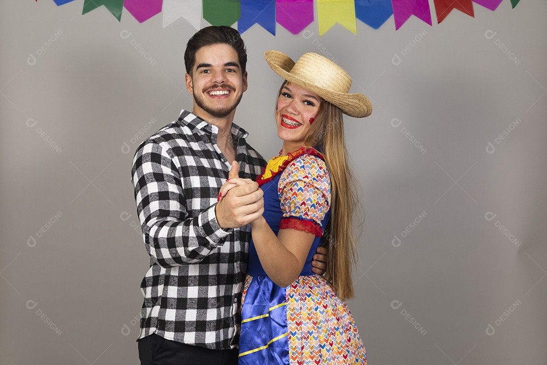 Lindo casal de jovens celebrando festa junina usando roupas típicas