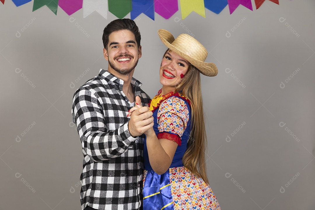 Lindo casal de jovens celebrando festa junina usando roupas típicas